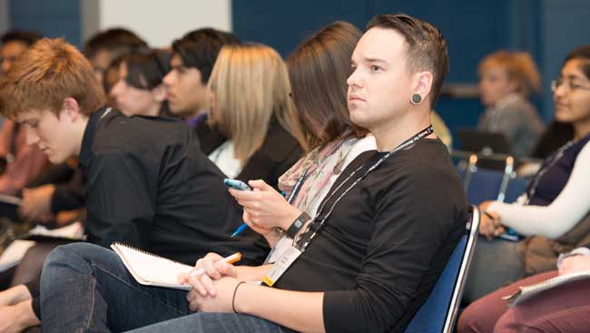 A male neuroscientist listens to a lecture.