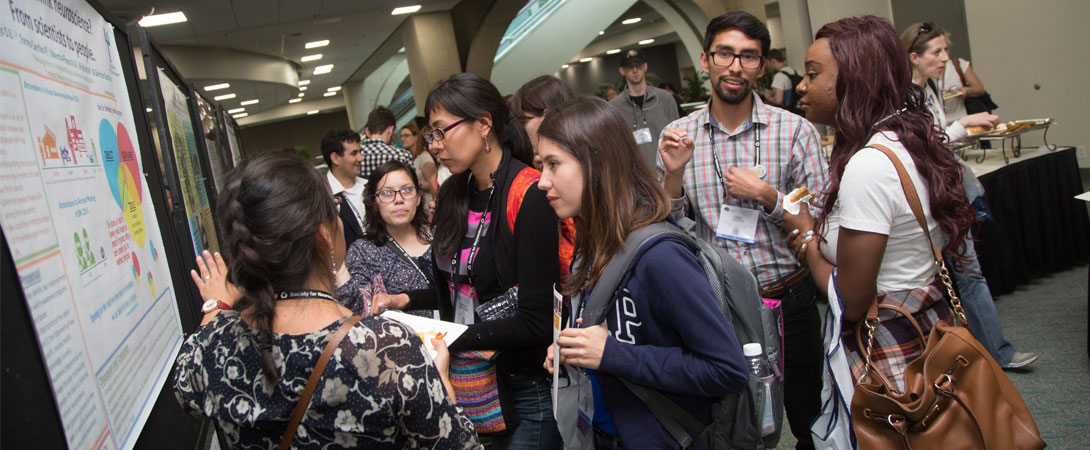 Several people gather at a scientific poster at the SfN annual meeting