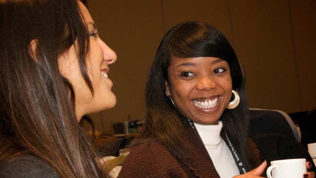 Two women smiling and talking.