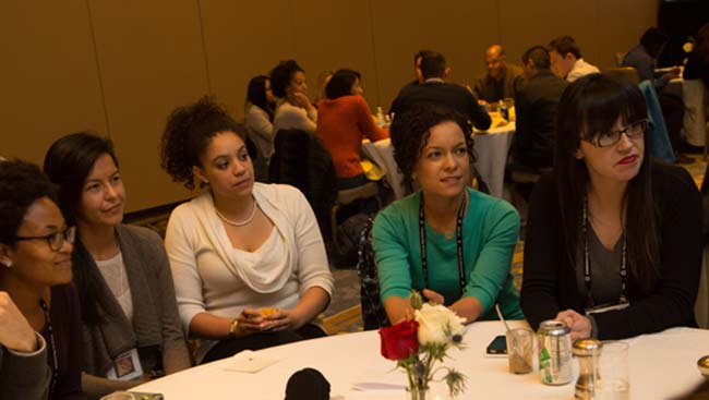 Five female neuroscientists listen to a speaker at the Celebration of Women in Neuroscience Luncheon. 