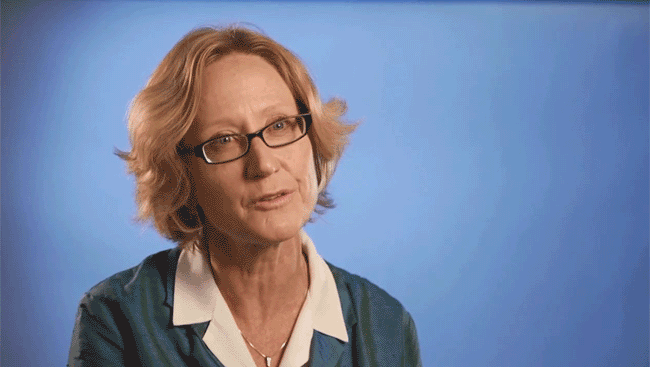 Female neuroscientist sits in front of a blue background and discusses what it takes to have a work/life balance.