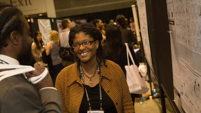 A female neuroscientist discusses her research with a colleague. 