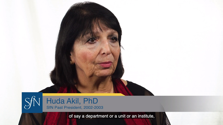 Huda Akil sits in front of a white backdrop and speaks about the importance of gender parity.