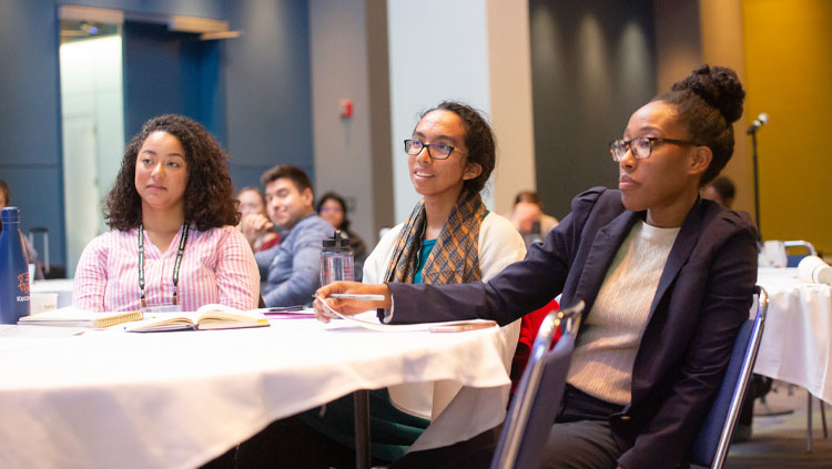 Three women sit at a round table listening to Short Course 3 at Neuroscience 2019.