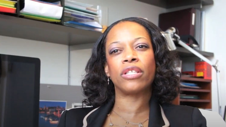 A woman speaks to the camera.