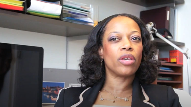 A woman speaks to a camera.