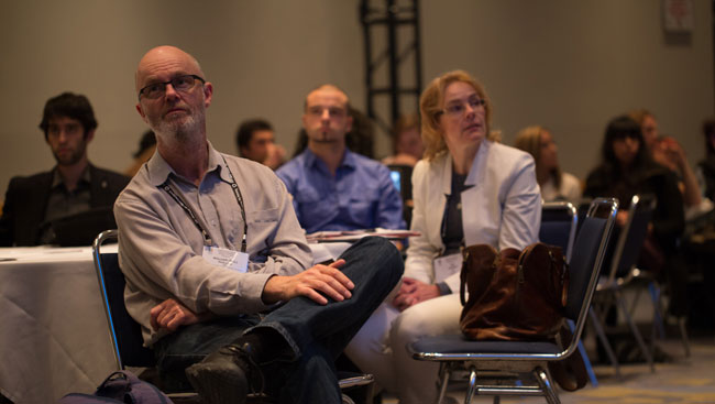 Neuroscientists sit listening to a lecture. 