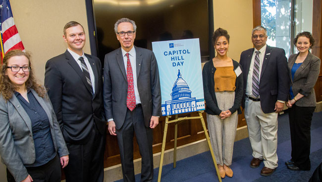 Neuroscientists stand around a sign for a picture at SfN's Capitol Hill Day