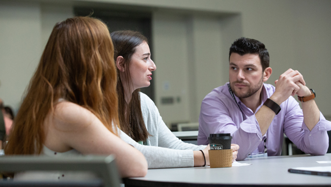Photo of three attendees having a discussion during the Professional Development Workshop, "Bringing a Student-Run Outreach Program to Your Institution"