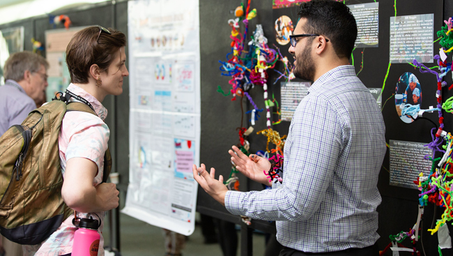 Poster presenter discussing research  with an attendee at Neuroscience 2018