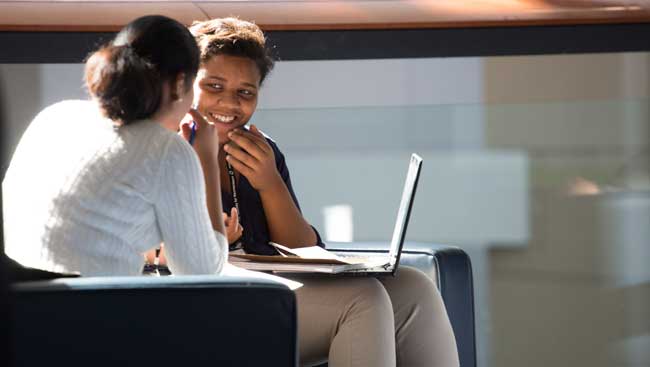 Two females share ideas about what to include on a CV. 