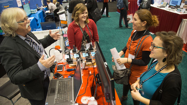 A group of neuroscientists learn about new technology at a conference. 