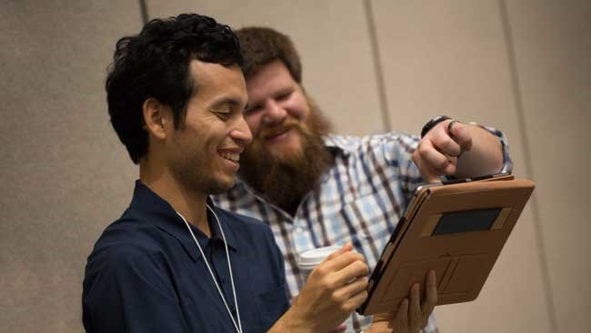 Two neuroscientists share data at a conference. 