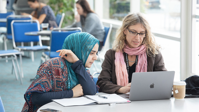 Neuroscience 2018 attendees looking at a laptop screen