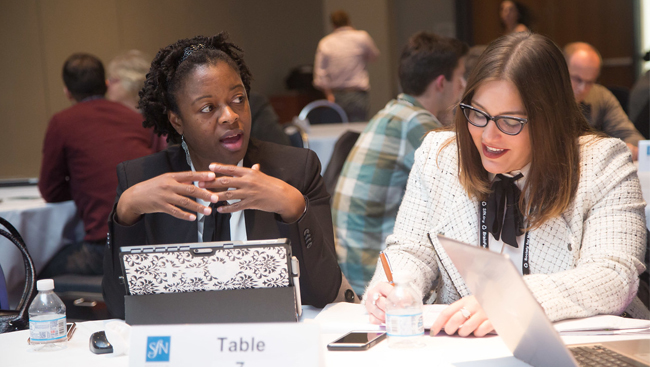 Attendees discussing at a table at SfN's annual meeting