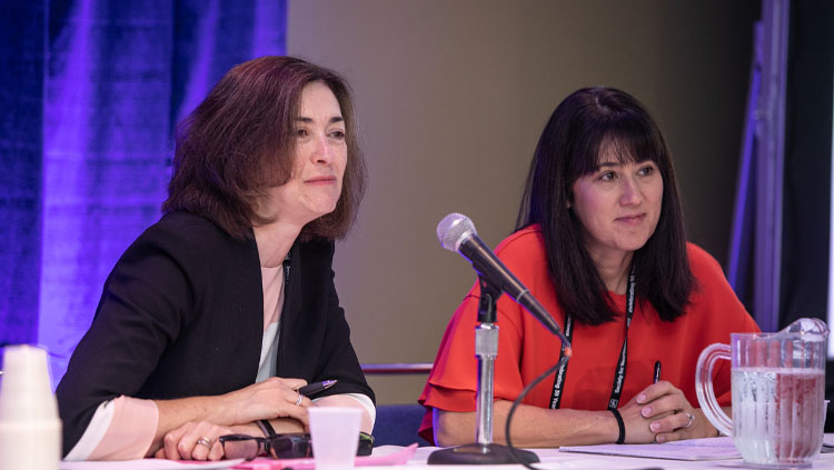 Two panelists listen intently while sitting at a table at a professional development workshop at Neuroscience 2019.