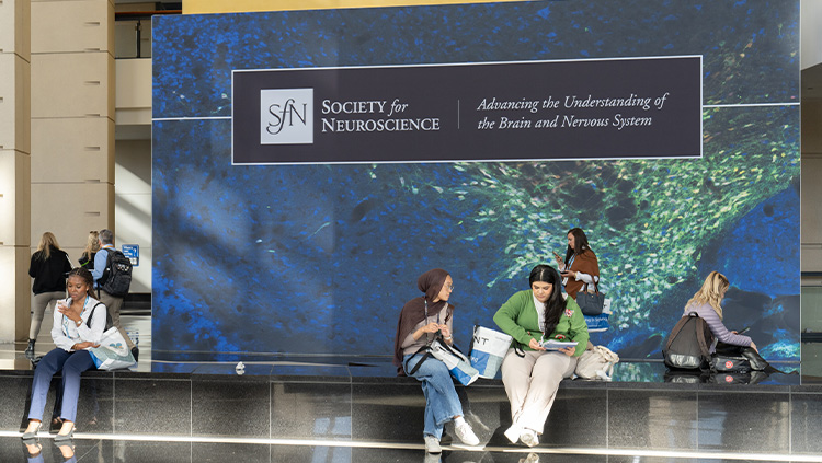 Neuroscience 2024 attendees in front of the SfN sign