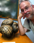 Image of Bill Grisham next to a brass statue of a brain.
