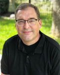 Headshot of Jim Newman wearing a black shirt.