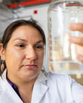 Naomi Lee examines the contents of a beaker. Photo taken by NAU Marketing.